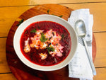 A serving of Divine Beef Borscht made with beef bone broth, displaying a hearty and flavorful traditional soup with a deep, rich colour and a variety of savory ingredients