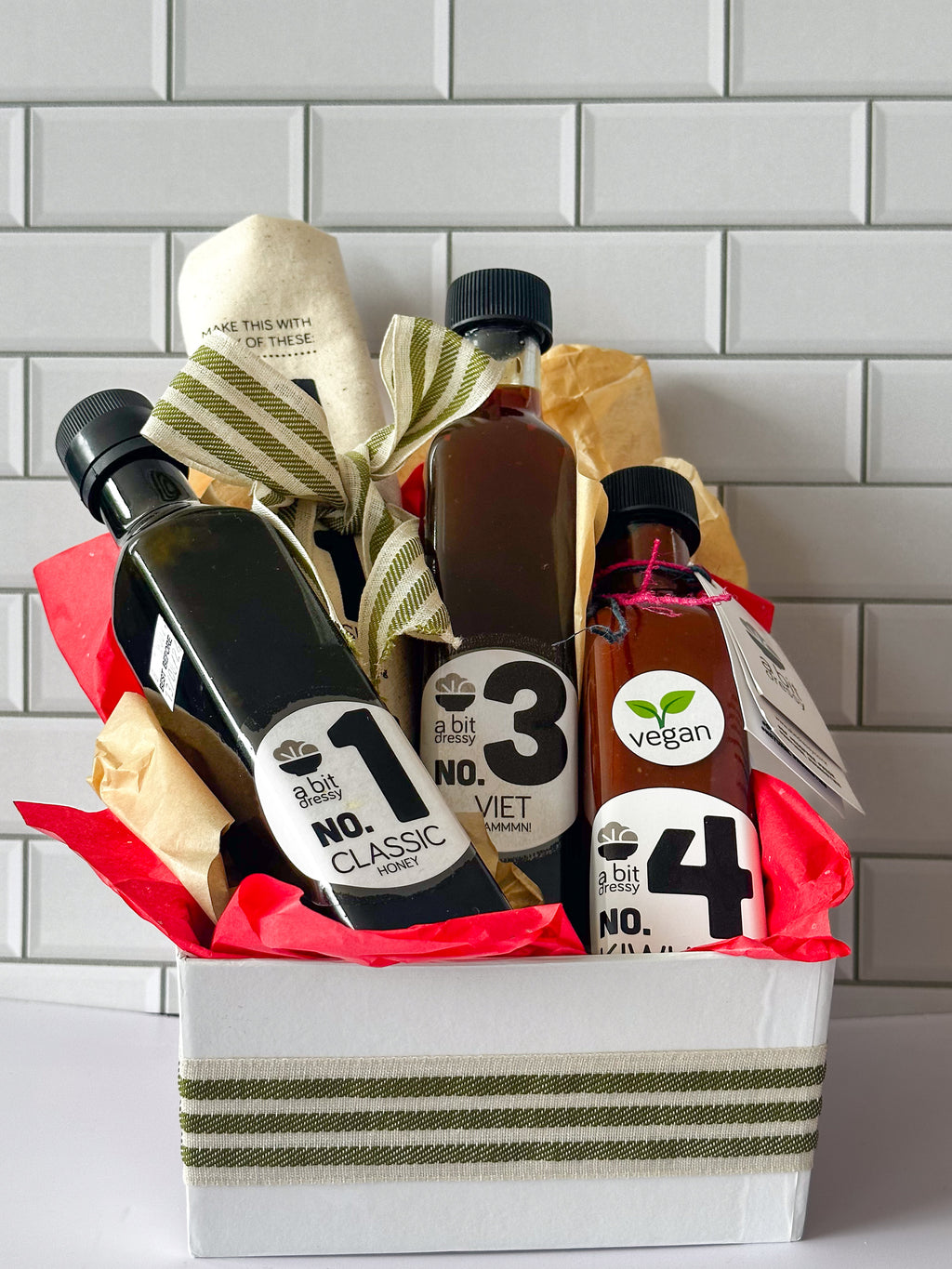 The Summer Sauces & Salads Sorted Bundle, featuring No.1 Classic Tart Dressing, No.3 Viet Dammmn! Dressing/Marinade, No.4 Smoky BBQ Sauce, and a large cotton tea towel, offering a combination of savory condiments and a practical kitchen accessory.