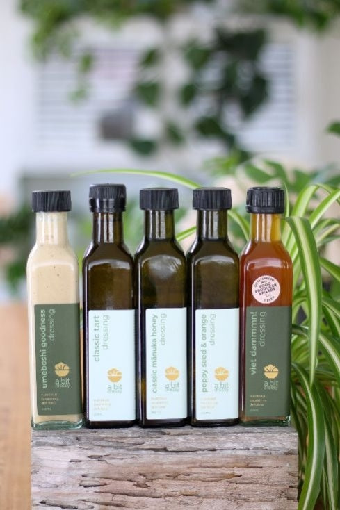 A demonstration of green herby sauce being generously drizzled over a fresh salad, enhancing its flavors with a burst of vibrant green goodness.