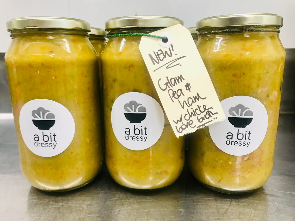 A 1-liter jar of Soup of the Month, featuring Rustic Pea & Ham with Chicken Bone Broth, a hearty and savory soup showcasing the delicious combination of peas, ham, and chicken bone broth.