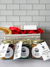 The Summer Condiment Bundle Christmas gift box, featuring three 270ml bottles of Spiced Grain Mustard, Epic Green Herby Sauce, and Lara's Glam Ham Glaze, along with a recipe tea towel, offering a delightful assortment of condiments and a practical kitchen accessory.