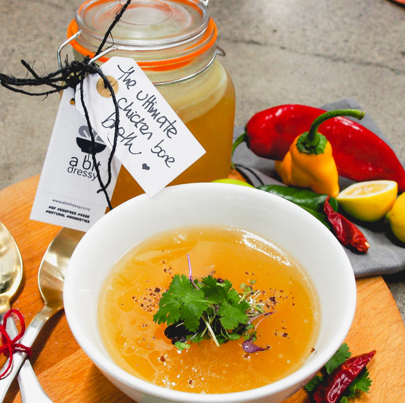 A steaming bowl of chicken bone broth, showcasing a rich and savory broth with a comforting and wholesome appeal