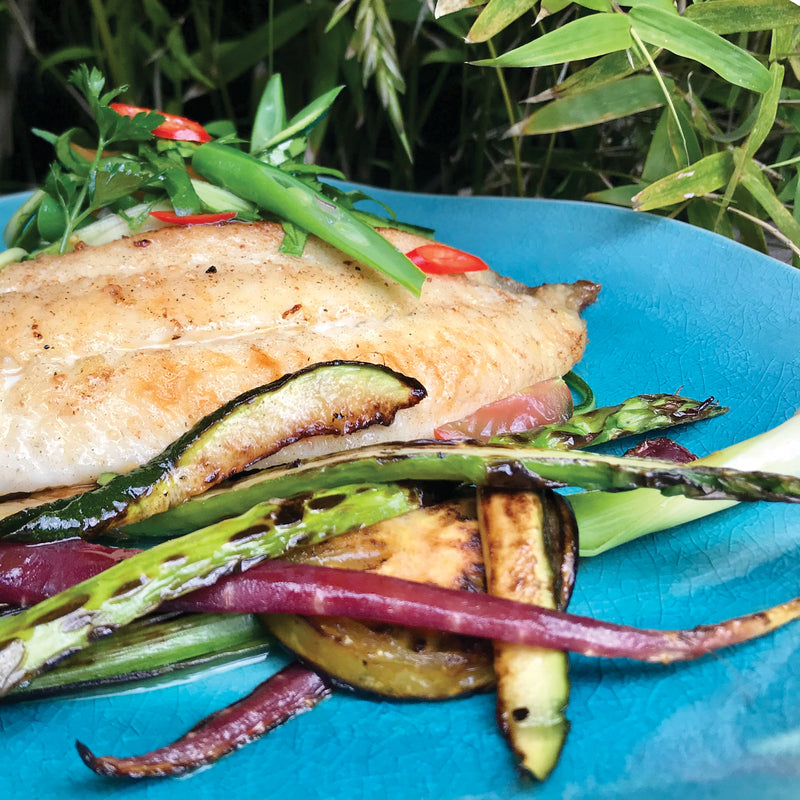 Lara's Viet Dammmn Dressing and Marinade drizzled over a dish of succulent chicken and a medley of vibrant vegetables, infusing the meal with Vietnamese-inspired flavors.
