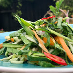 A fresh salad beautifully drizzled with Viet Dammmn!! dressing, adding a burst of savory flavor to the dish.