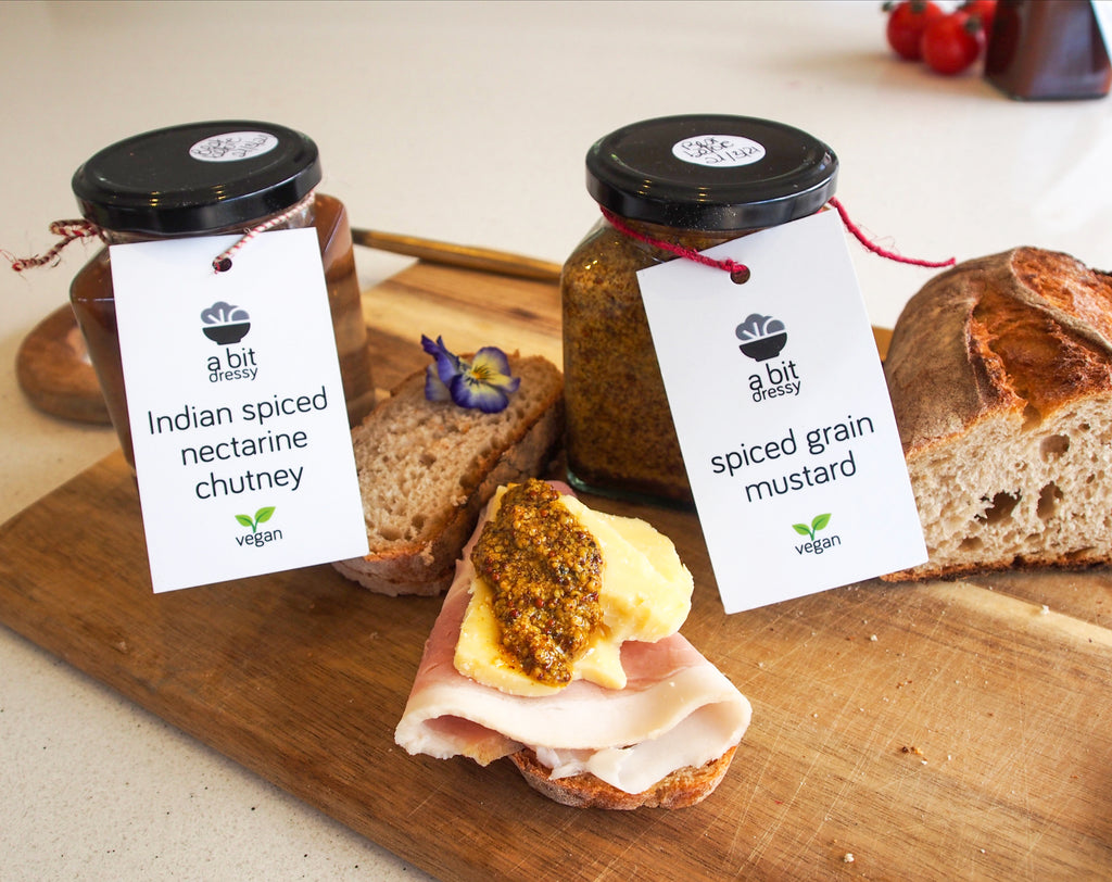 Jars of Indian Spiced Nectarine Chutney and Spiced Grain Mustard, both condiments offering a delightful blend of flavors and spices, perfect for enhancing various dishes