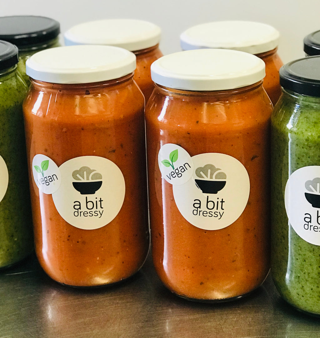 Several glass jars filled with Superb Gazpacho Soup, showcasing a vibrant and refreshing soup made from a blend of fresh ingredients.