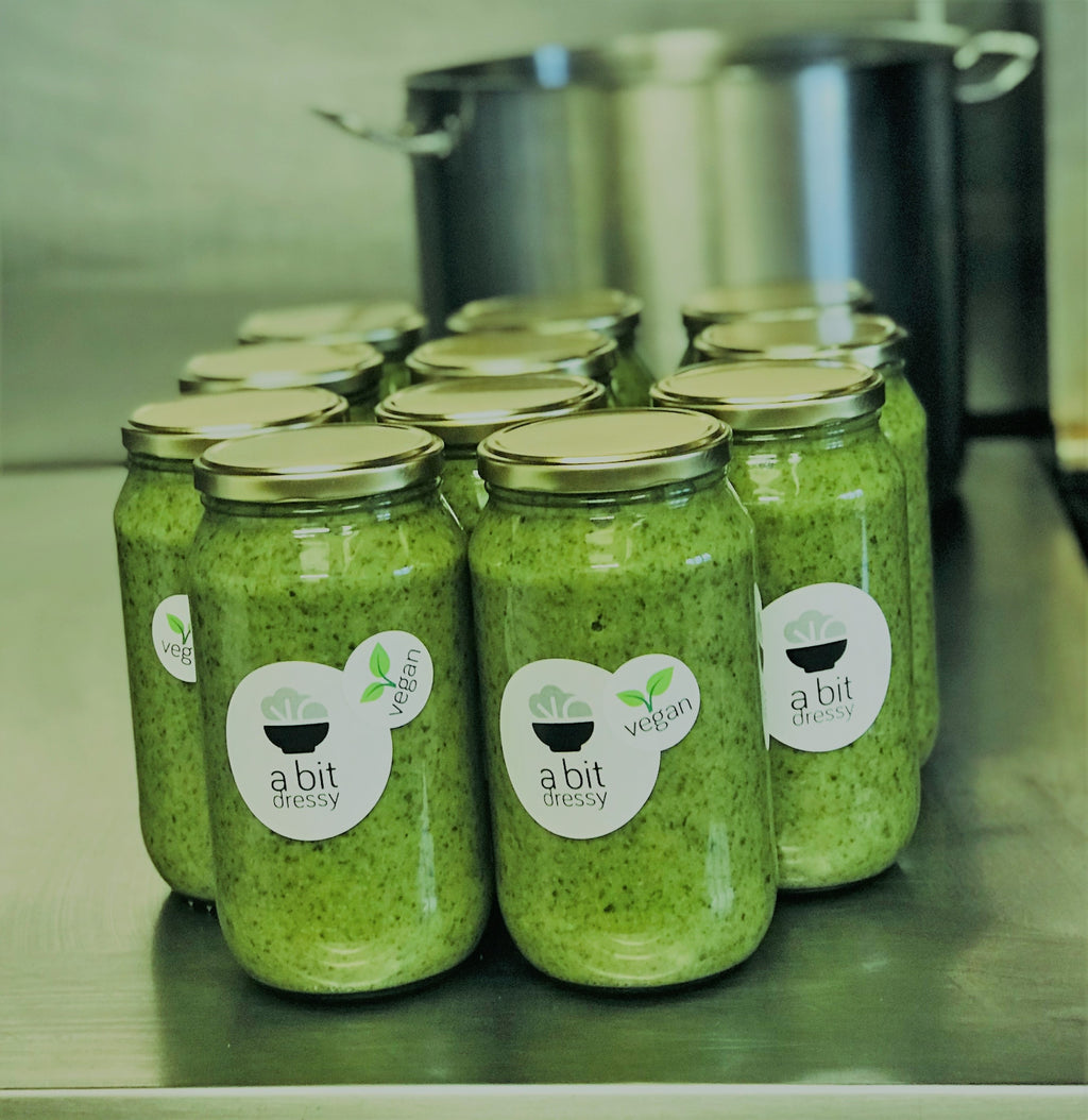 Several glass jars filled with vibrant Green Goddess soup, featuring a luscious green color and an assortment of fresh, wholesome ingredients