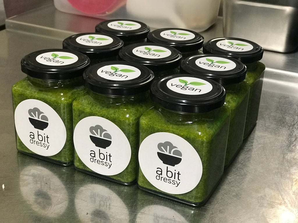 Jars of green herby sauce, featuring a vibrant and aromatic blend of fresh herbs and seasonings, ready to enhance your culinary creations