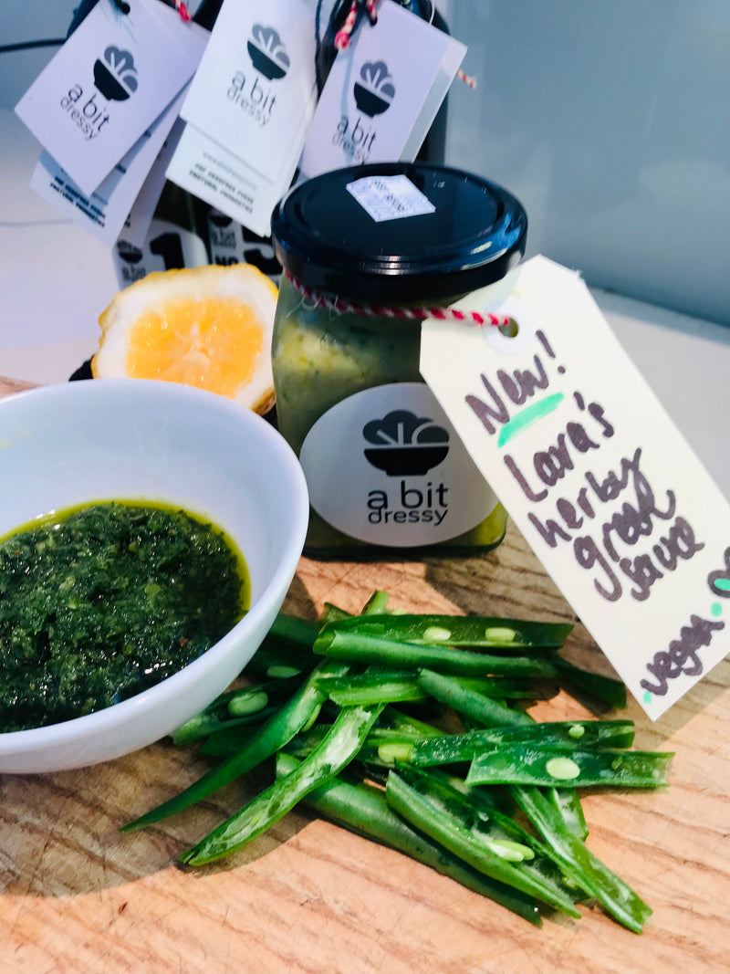 A jar of green herby sauce, featuring a fresh and vibrant mixture of green herbs and seasonings, ready to add a burst of flavor to your dishes