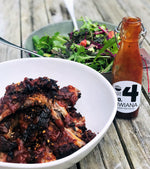 A table set with a bowl of ribs and a bowl of salad, complemented by the Number 4 Kiwiana BBQ Sauce, creating a delicious and satisfying meal.