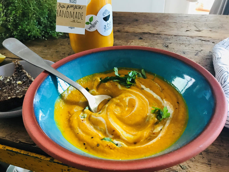 A bowl of Vegan Thai Pumpkin Soup with coriander, lemongrass, and chili, featuring a flavorful and aromatic combination of ingredients.
